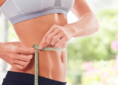 The girl measures the size of the waist