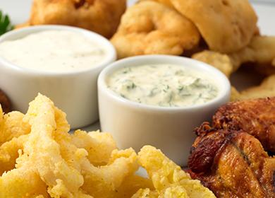 Bowls with spicy sauce for meat and onion rings