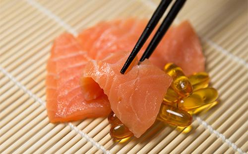 Pieces of red fish and fish oil capsules