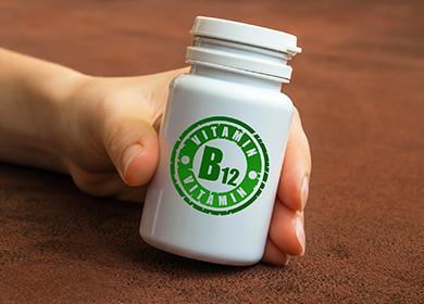 Hand holds a bottle with vitamins.