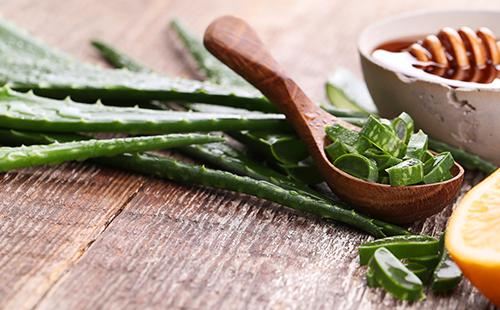 Aloe leaf in a wooden spoon and honey