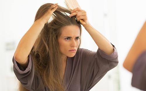 Woman examines her hair