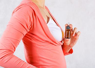 Woman in salmon top holds a bottle of oil