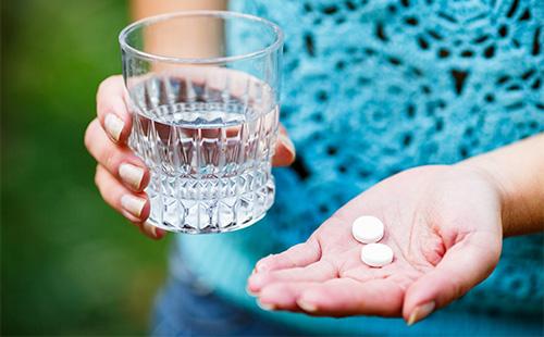 Two white pills on the palm