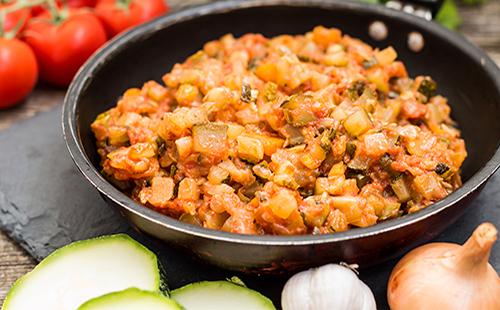 Stewed vegetables in a pan with zucchini and onions