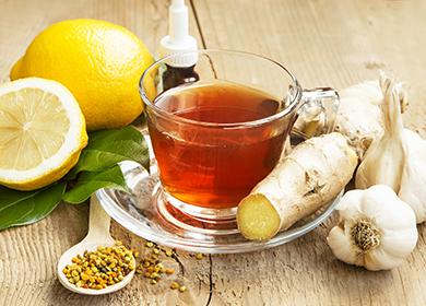 Around the cup are lemons, ginger root and garlic.