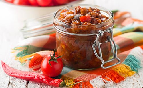 Jar with canned zucchini, tomatoes and chili peppers