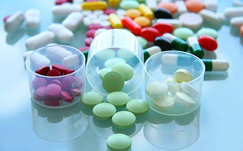 Multicolored pills in glasses