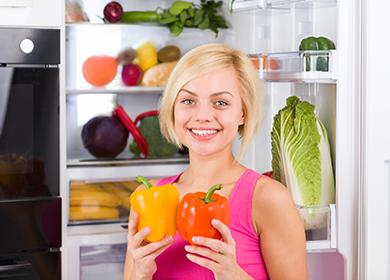 The girl holds two bell peppers in her hands