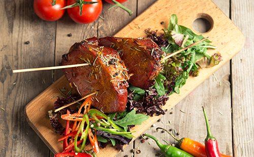 Appetizing boiled pork with tomatoes and herbs