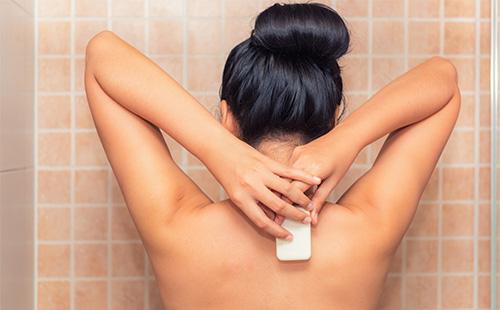 Woman washes her back