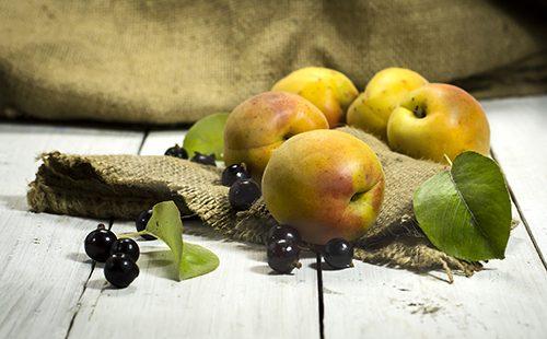Apricots and black currants on a wooden table