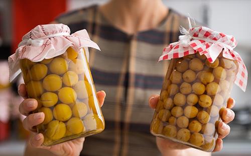 Stewed cherry plum in banks in the hands of a woman