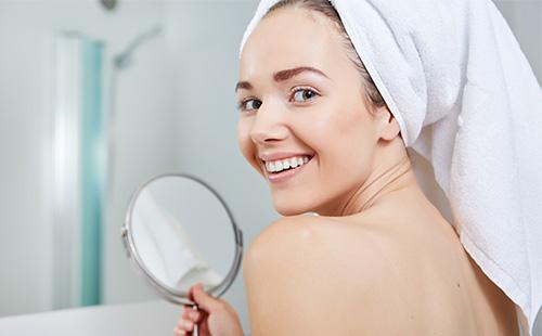 Woman holds a mirror and smiles