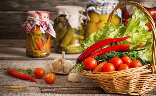 Vegetables in a basket and in jars