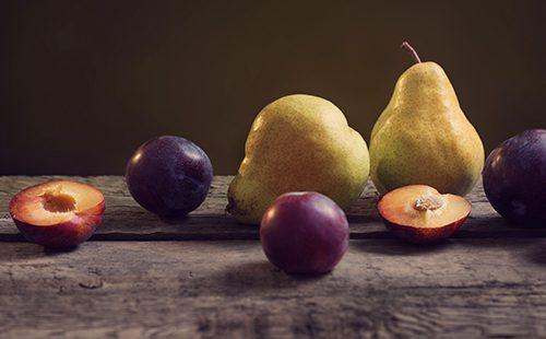 Plums and pears on a wooden table