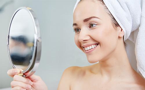 Young girl looks at herself in the mirror