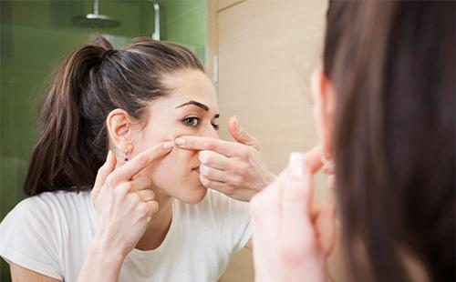 Girl squeezes a pimple