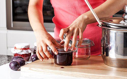 Woman closes a jar of jam