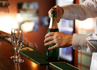 Bartender opens a bottle of champagne