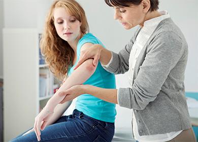 The doctor looks at the patient's elbow