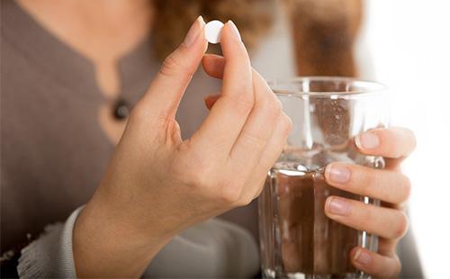 Woman about to drink a pill