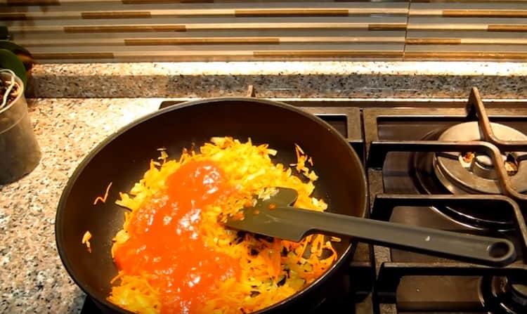 Add the grated carrot to the onion, season it all with tomato paste.