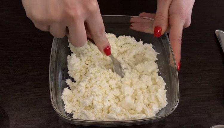 To prepare the curd filling for pancakes, first grind the curd.
