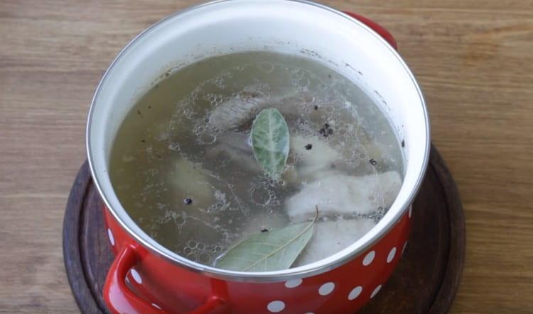 Add pork ribs to the broth, as well as peppercorns and bay leaf.