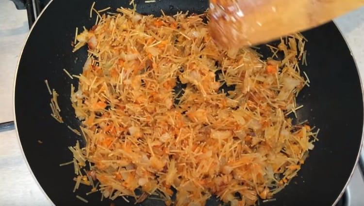 Fry the noodles with vegetables for several minutes.