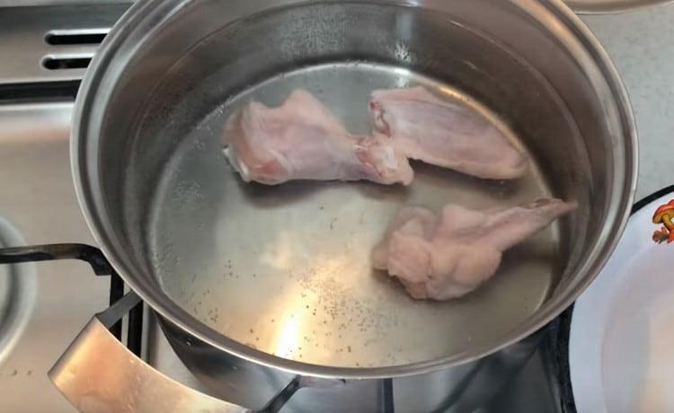 Dip chicken wings in water, leave to cook.