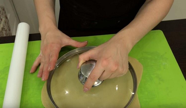Each piece is thinly rolled out with a rolling pin and a lid is cut from it cake.
