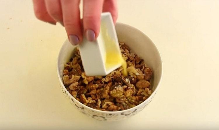 Pour the dried walnuts in a pan with melted butter.