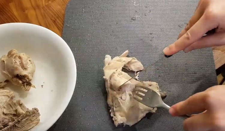 We take out the meat from the pan and separate from the bones.