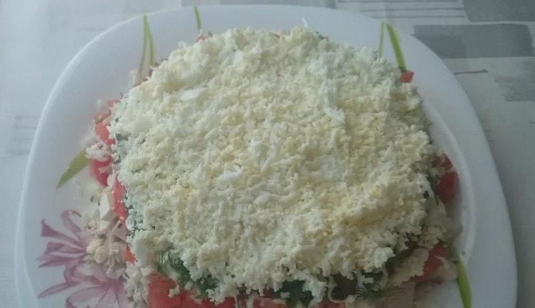 Grate boiled eggs and spread them the next layer of the dish.