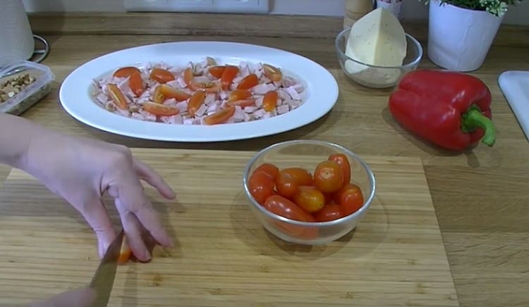 We cut the cherry tomatoes into quarters and spread them evenly on top of the chicken.