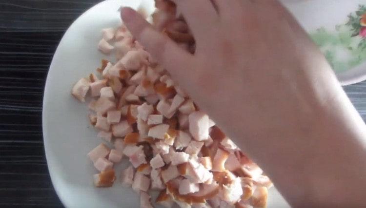 We spread the chopped chicken meat with the first layer of the dish.