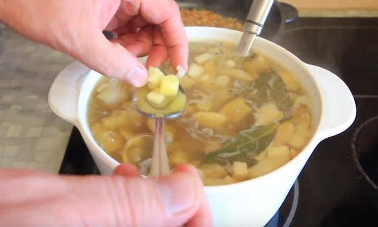 Check potatoes for readiness.