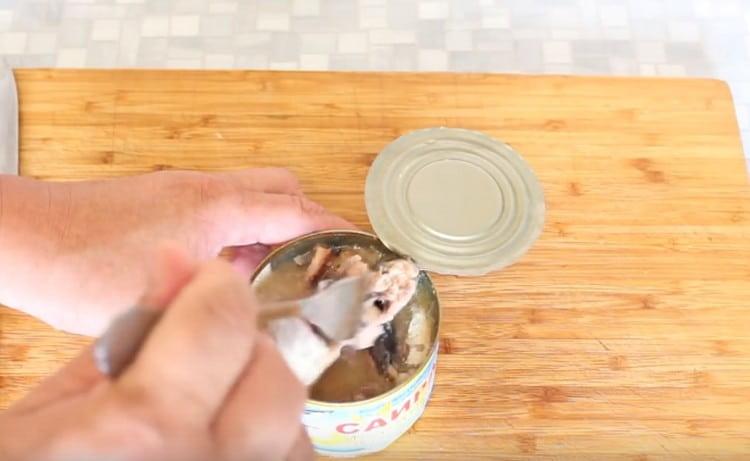 Open canned food and large pieces of fish a little knead with a fork.
