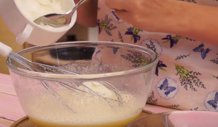 Add sour cream with soda to the egg mass.