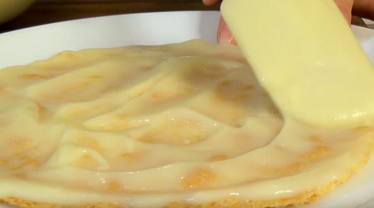 We spread the cake, grease it with cream.