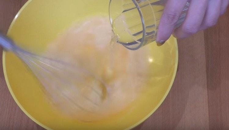 Pour water into the egg mass with vodka and vinegar.