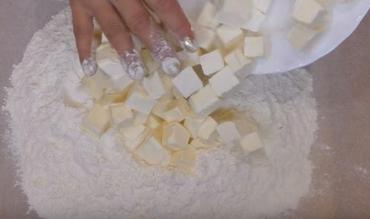 Dice the cold butter and combine it with the sifted flour.