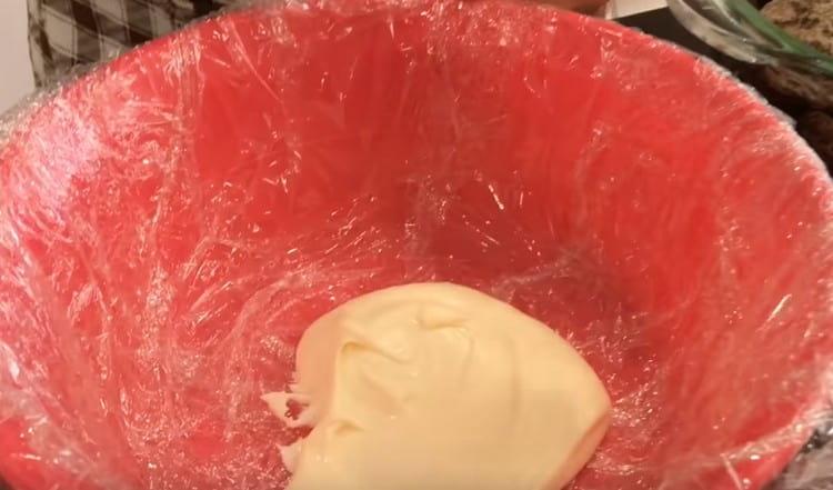 Cover the form or deep bowl with cling film and grease the bottom with cream.