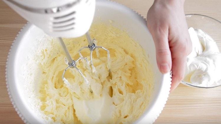 In parts, we introduce sour cream into the oil mass.