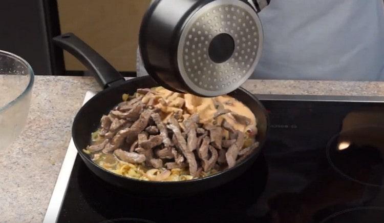 Add the meat and sauce to the onion in the pan.