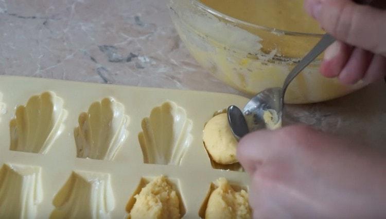 We spread the shape of the thickened dough with a spoon.