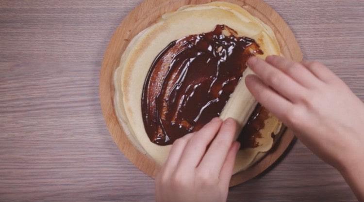 We spread a slice of banana and wrap it in a chocolate-coated pancake.