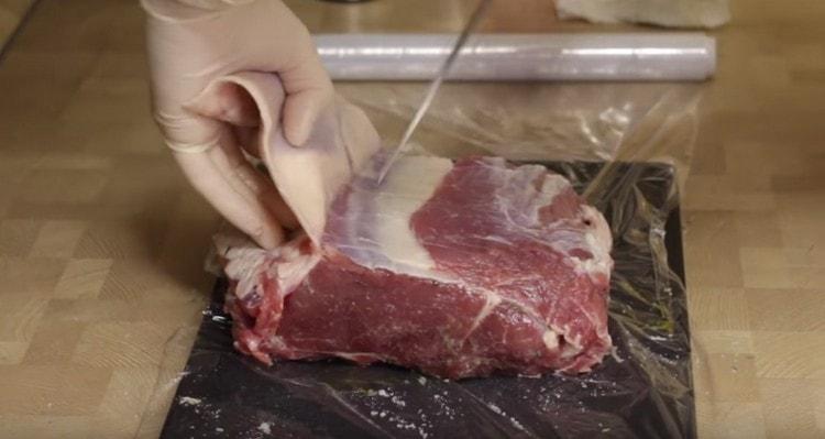 We clean a piece of meat from films and fat.