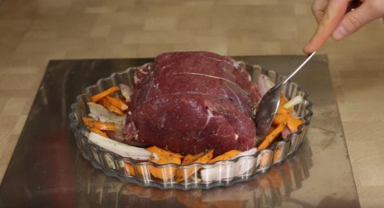 We spread the meat in a baking dish, lay the vegetables near it.